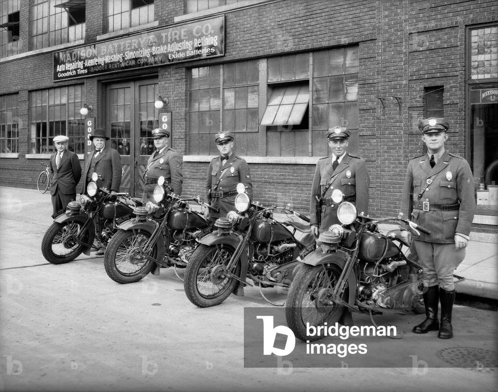 4 Dane County motor policemen shown with 4 Harley Davidson motorcycles in front of Madison Battery and Tire, 250 State Street, Madison, Wisconsin, 1931