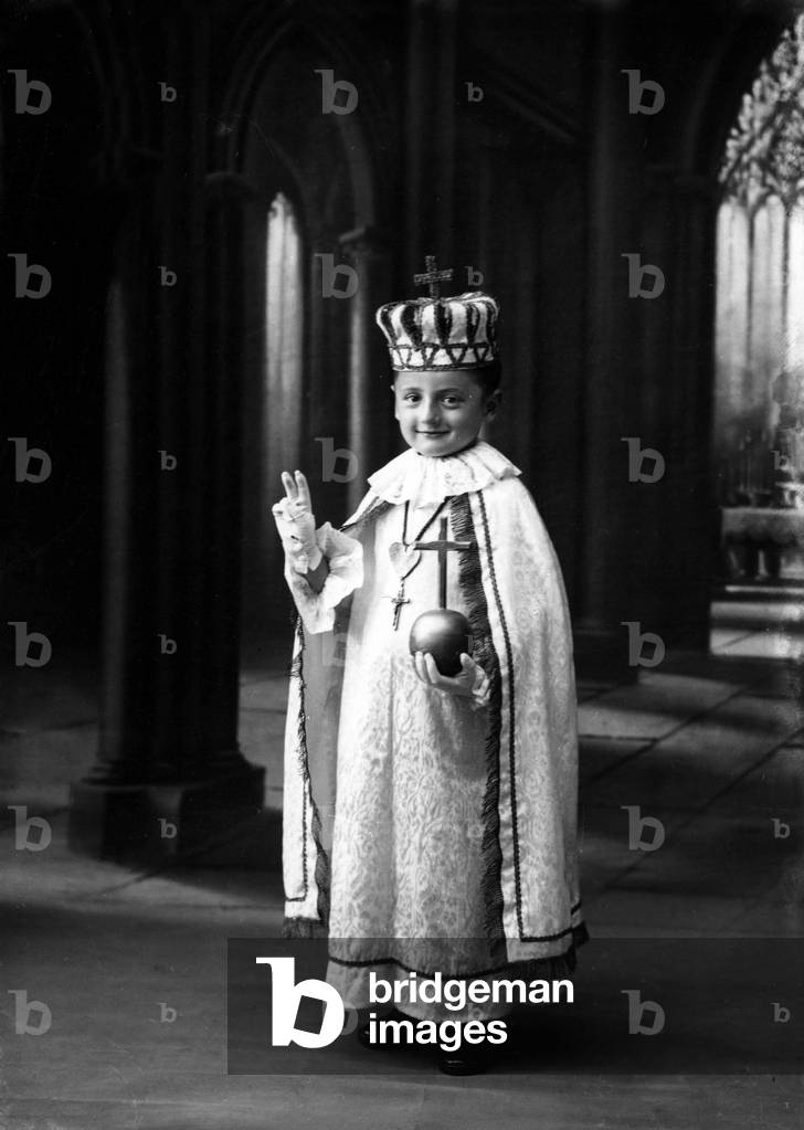 Boy dressed up as the Jesus of Prague (crown, coat, globe...)