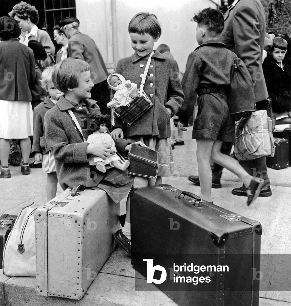 Image de Photographie représentant Petites filles avec leurs poupées à la gare de Montparnasse pendant les vac