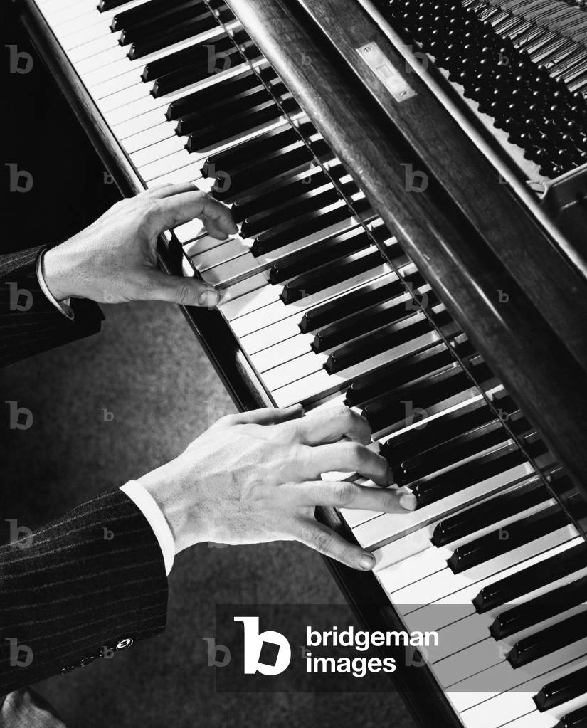 Immagine di Fotografia "Vista dall'alto delle mani di un uomo che suona il piano", b/w