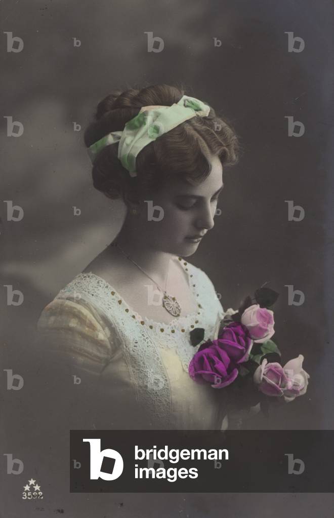 Mädchen, das in einen Rosenstrauß blickt (Farbfoto)
