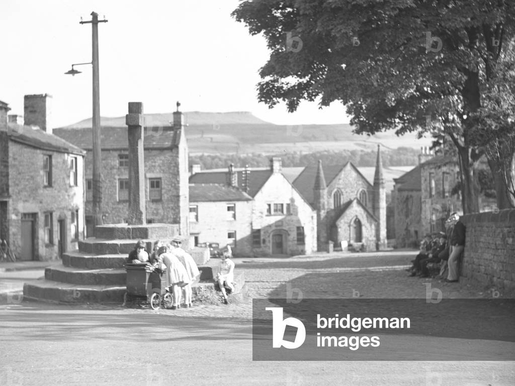 Image de Photographie représentant Une vue sur le centre d'un village avec une croix commémorative 1930 par Jo
