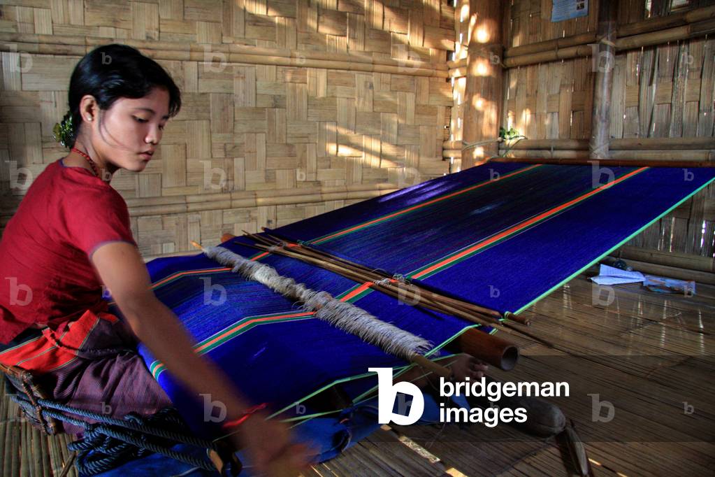 Una donna etnica che intrecciava abiti con un telaio a mano a Thanchi a Bandarban, Bangladesh. 1 dicembre 2009