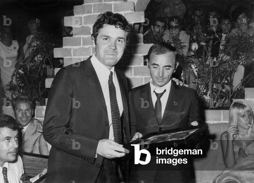 Pierre Perret mentre consegna un premio a Charles Aznavour, 1966 (foto)