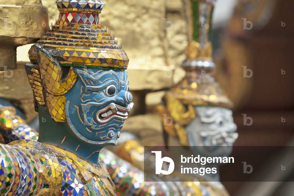 Statue guardiane sulla base di un chedi d'oro a Wat Phra Kaeo, Thailandia (foto)