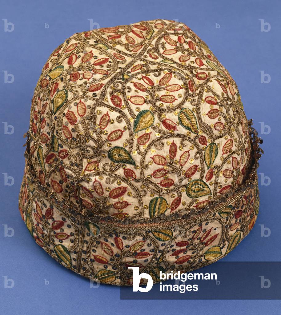 A Near Eastern gentleman's linen nightcap embroidered in red and green, with silver gilt thread and sequins, t