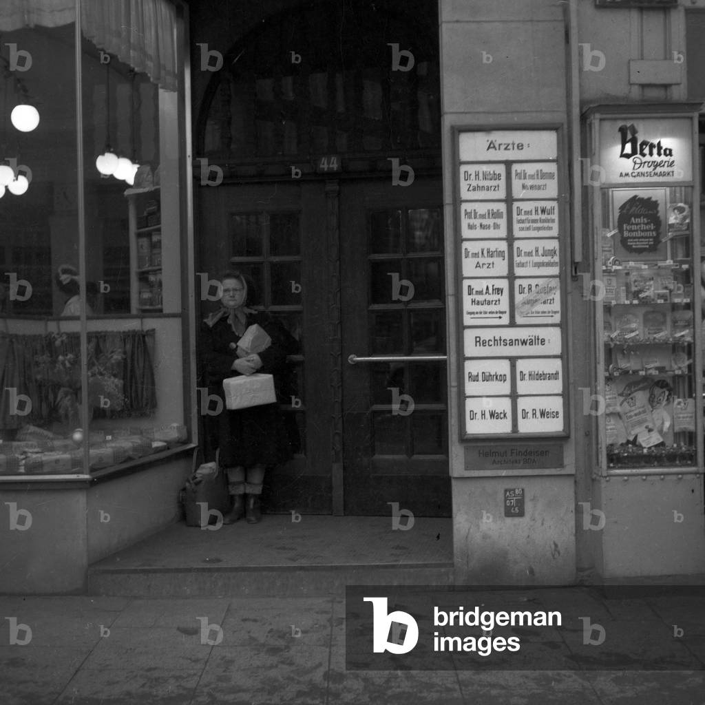 "Una donna in piedi all'ingresso di una casa a Gaensemarkt ad Amburgo", b/w