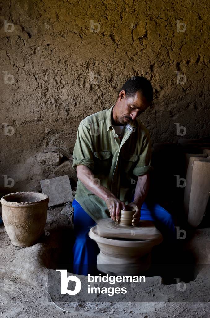 Potter jetant une tasse sur son volant dans la poterie du village de montagne berbère