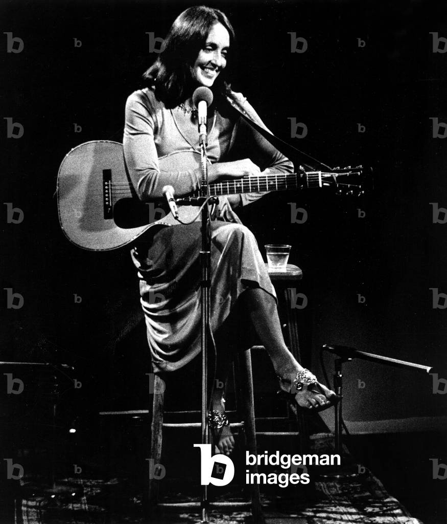 Image of Joan Baez relaxes between songs during her special