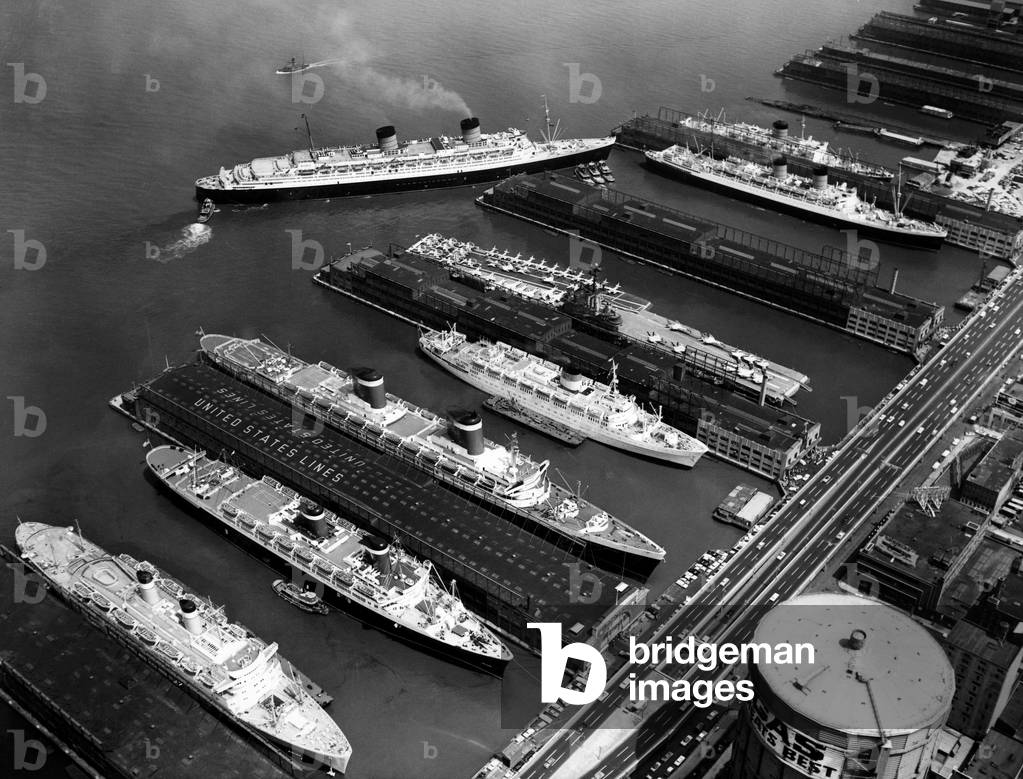 Image of Luxury liners flanking an aircraft carrier at piers along the