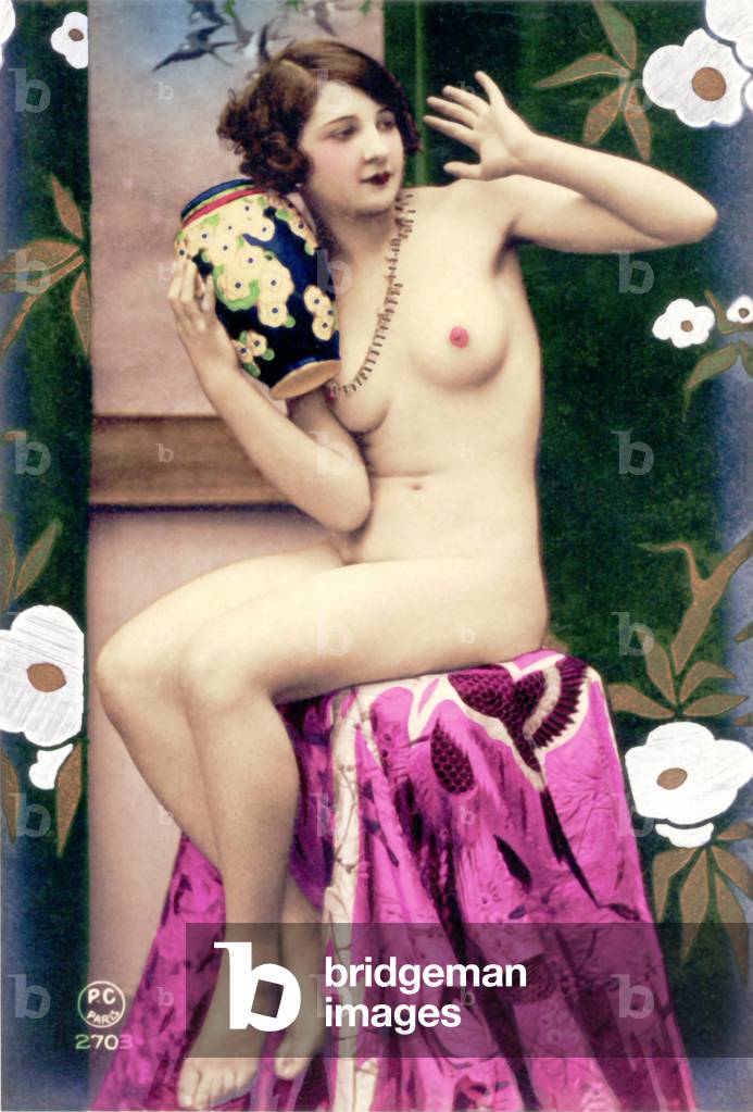 Una donna nuda seduta su una sedia, indossando una collana e tenendo un vaso con disegno floreale, 1925 (foto 