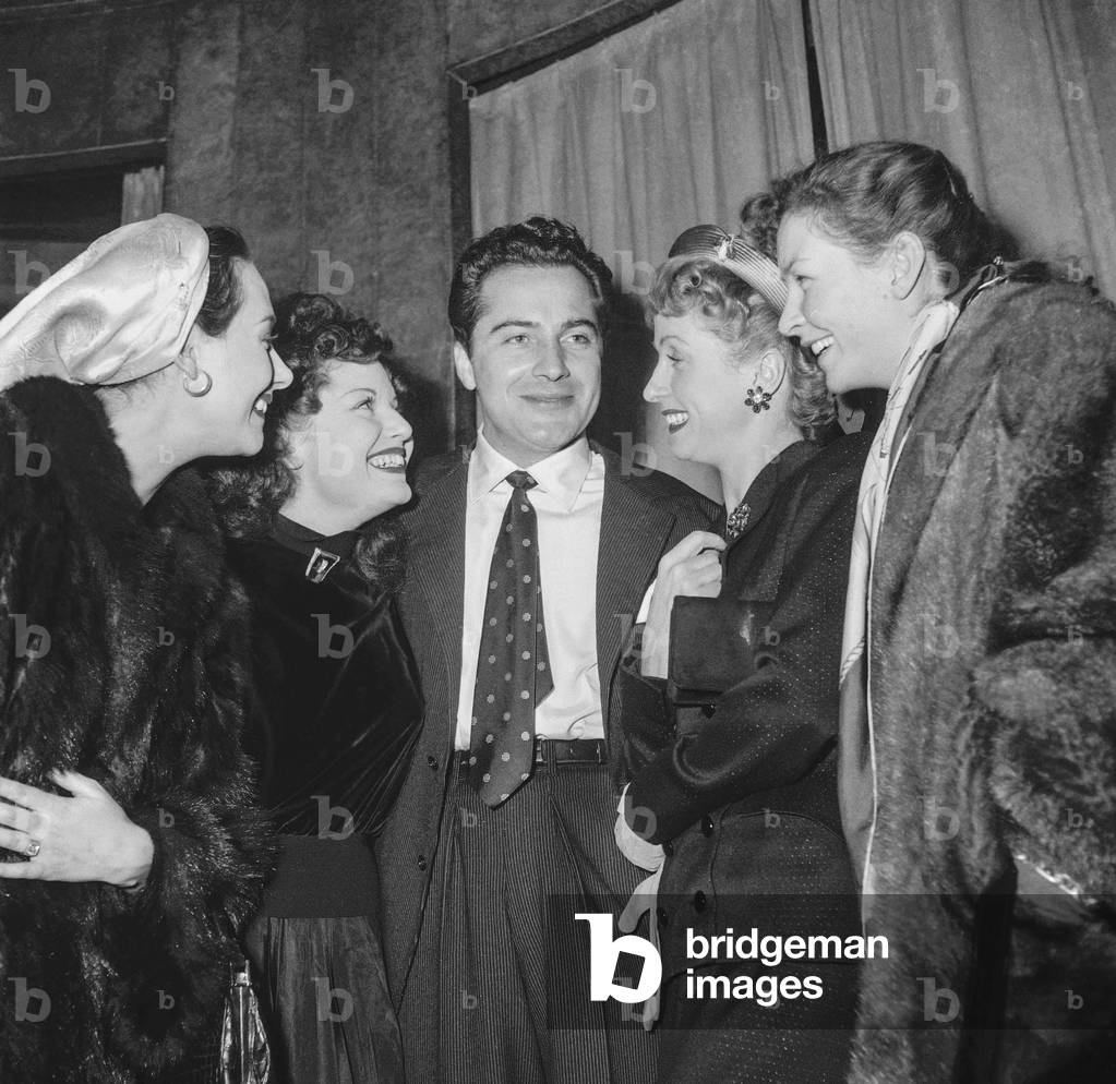 L'attore italiano Rossano Brazzi durante una festa a Parigi, l'8 febbraio 1951, circondato da Marcelle Derrien
