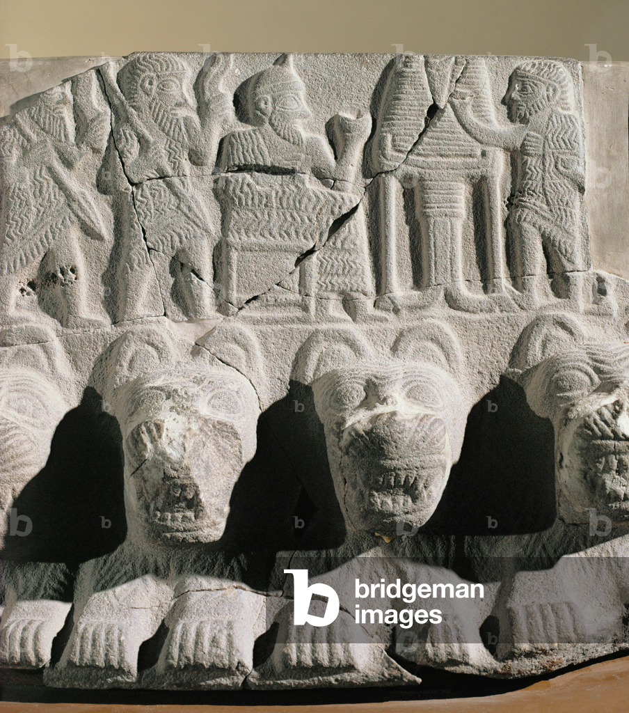 Roi ou souverain dans son rôle de prêtre, assis devant une table d'offrandes, consacrant le pain.