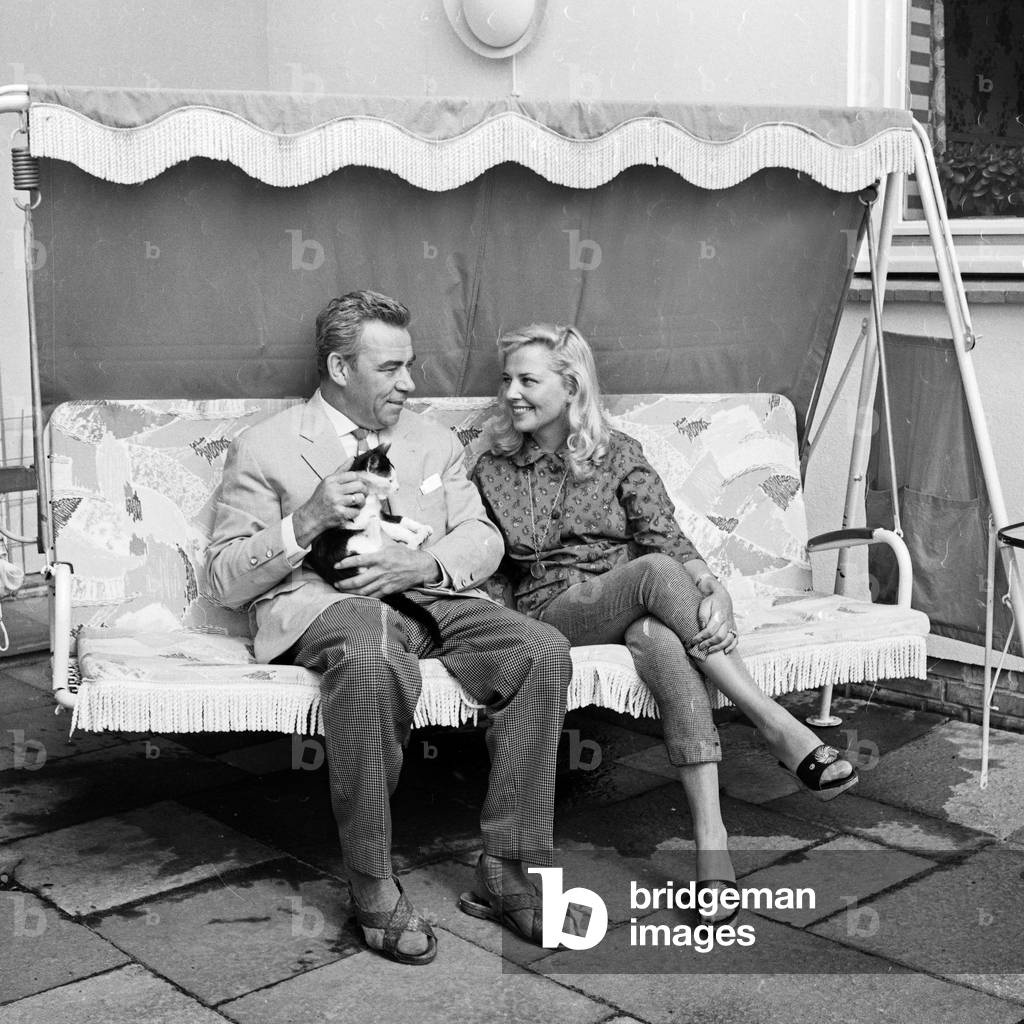"Deutscher Schauspieler und Moderator Peter Frankenfeld mit seiner Frau Lonny Kellner auf einer Veranda Schauk