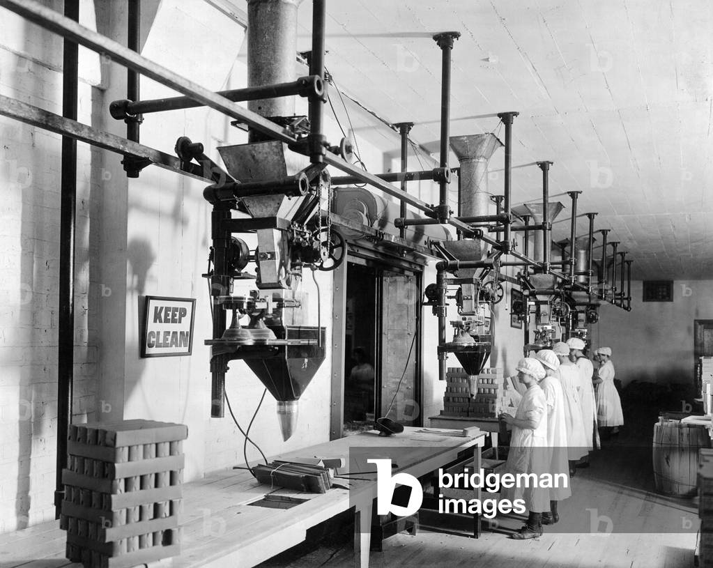 Vereinigte Staaten: um 1913 Arbeitnehmerinnen, die Scott Füllmaschinen in einer Fabrik benutzen. (s/w Foto)