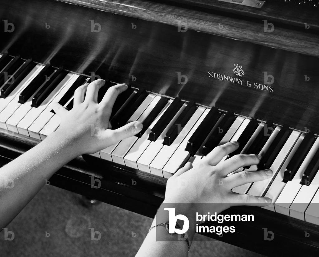 Immagine di Fotografia "Inquadratura ravvicinata delle mani di una persona che suona il piano", b/w