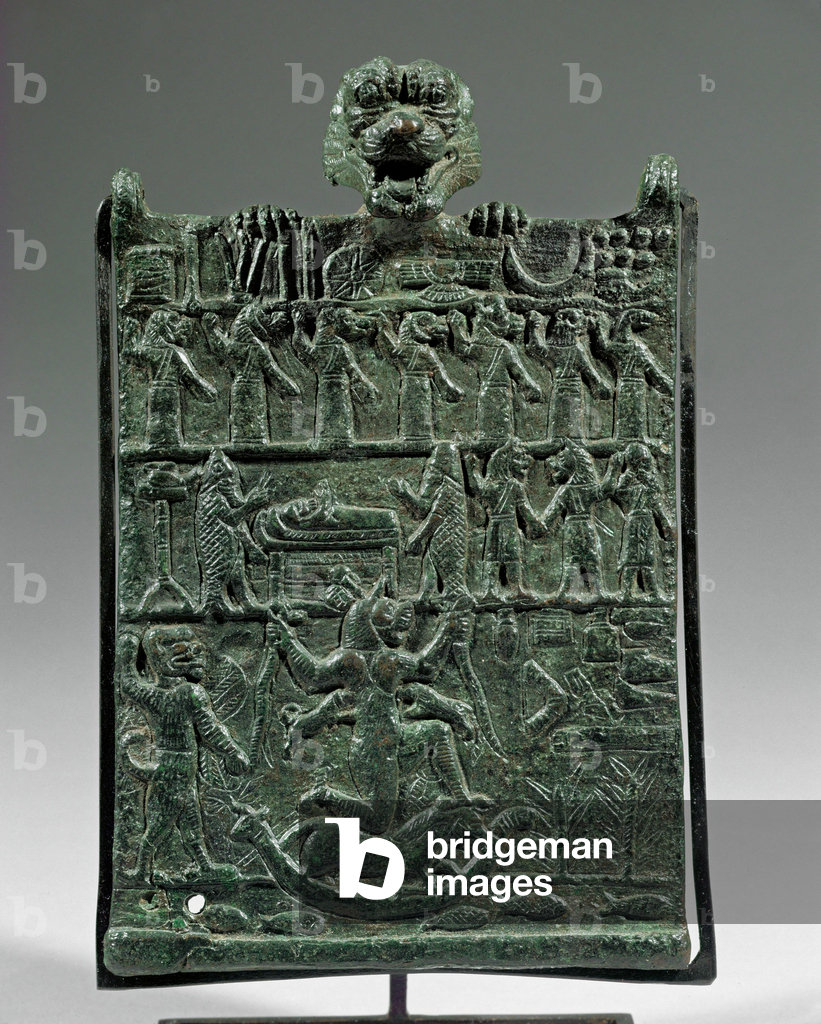 Il dio-demone Pazuzu scruta oltre il bordo di questa targa di bronzo ...
