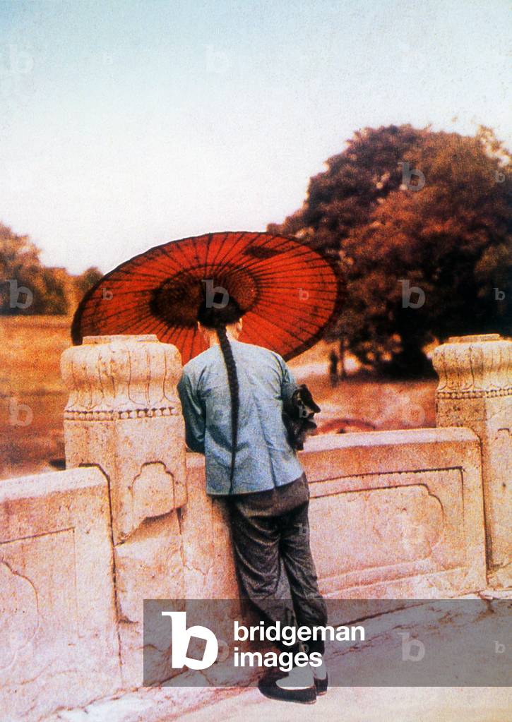 Image of China A Chinese man with an umbrella and long queue,