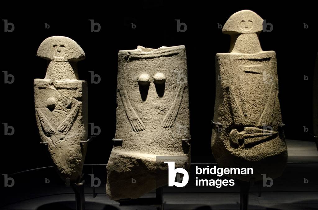 VORGESCHICHTE drei Exemplare einer Stelenstatue, zwei Frauen und ein Mann mit einer Axt und einem Dolch