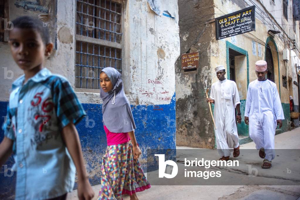 "Persone locali in una stretta strada della città di Lamu nell'isola di Lamu" 2020 di Sergi Reboredo