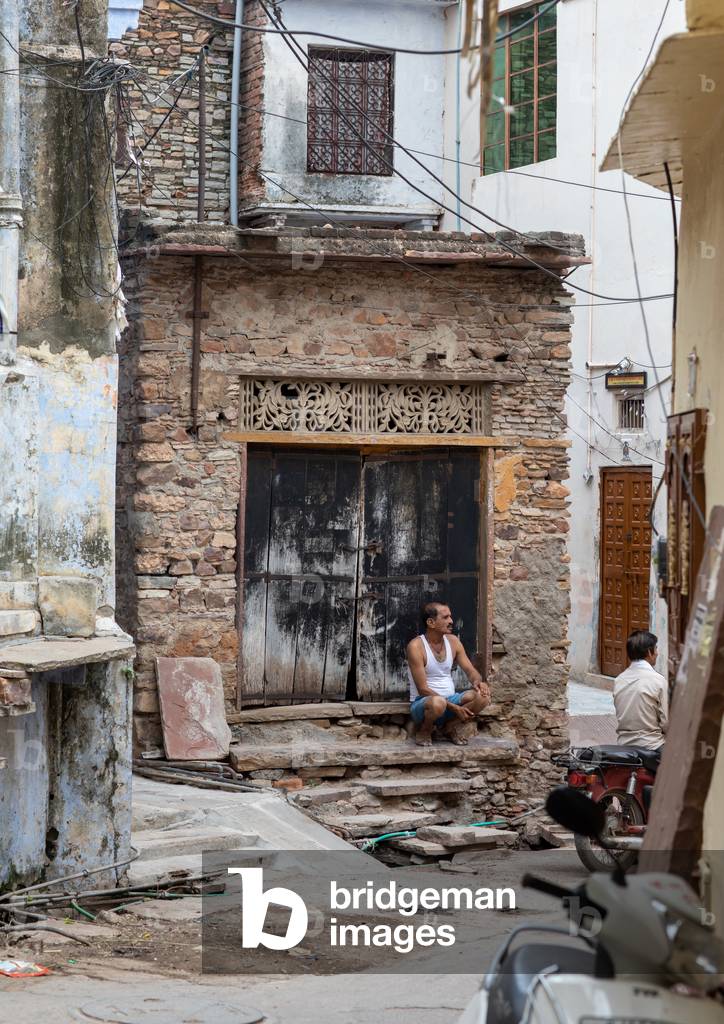 Immagine di Fotografia "Uomo indiano seduto davanti a una vecchia porta" 2019