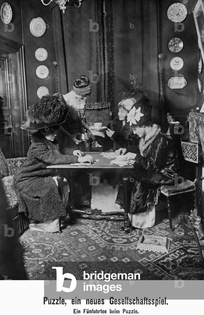 Ladies' company doing a jigsaw puzzle, 1910 (b/w photo)