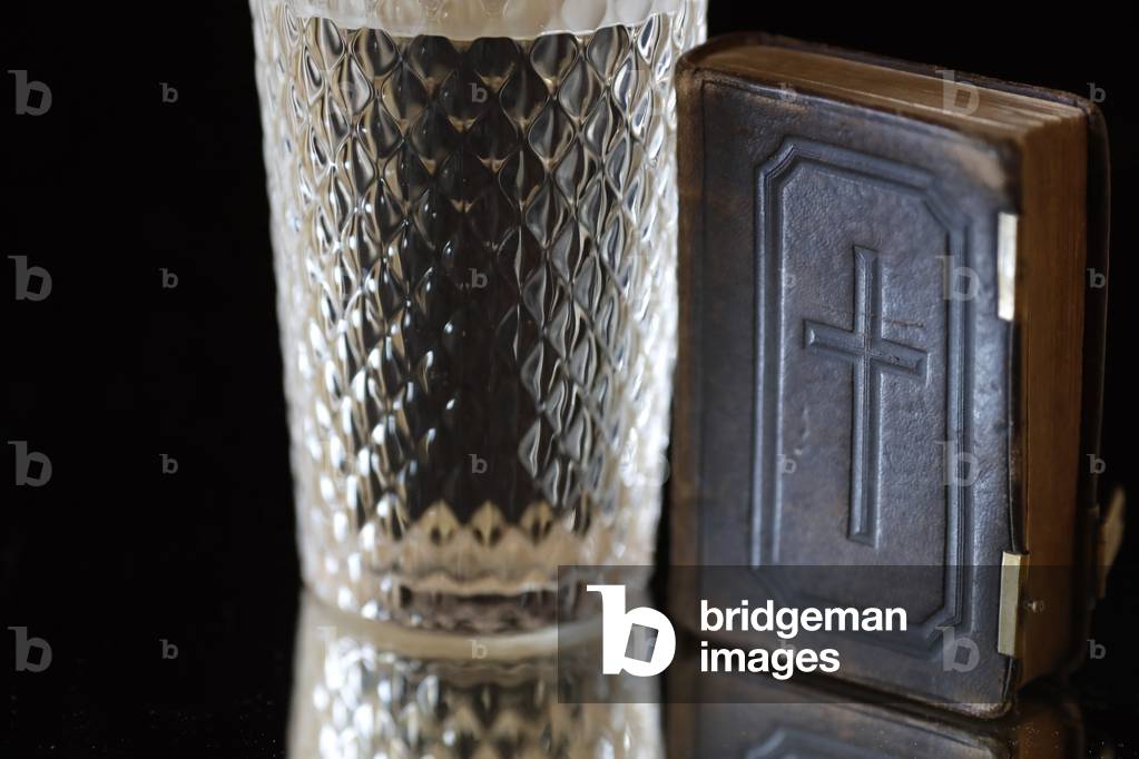 Image of Glass of water, and old Bible during Lent. A solemn