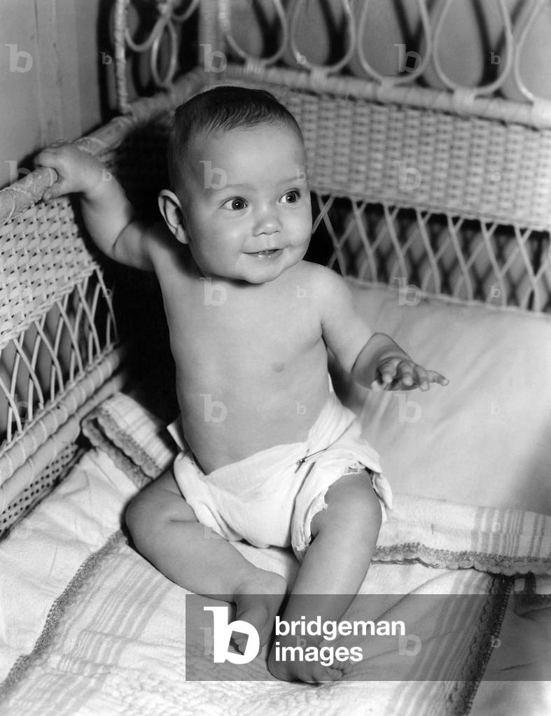 Image of Baby sitting up in crib, 1940s (b/w photo)