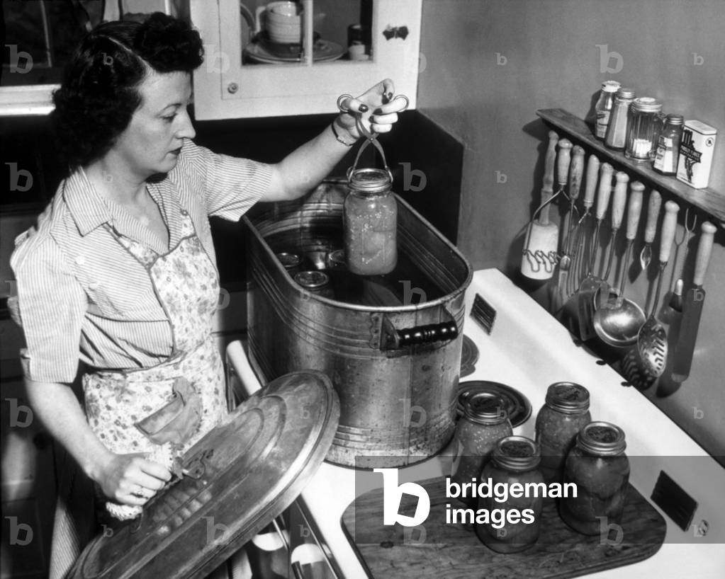 Image of Photography depicting Housewife Preserving Tomatoes from Her Victory Garden 1944, b/w