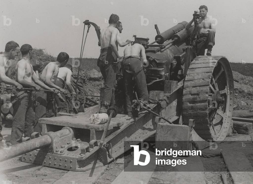 Immagine di Fotografia "Fotografia di un equipaggio di armi senza magliette caricare un howitzer" 1917 di Engl