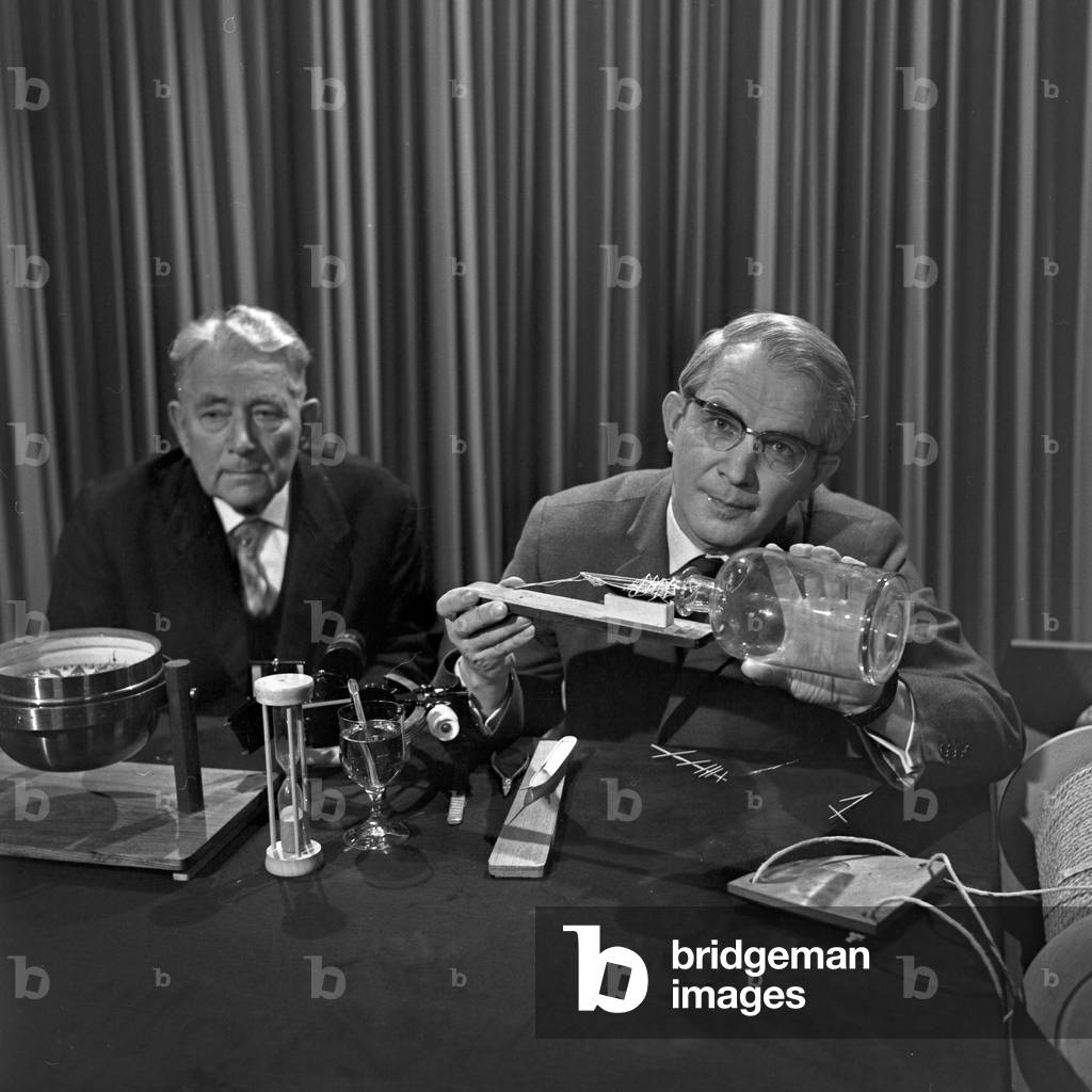 "Presentatore Friedrich Karl Ries (a destra) che spiega come elaborare un shipin-a-bottle", b/w