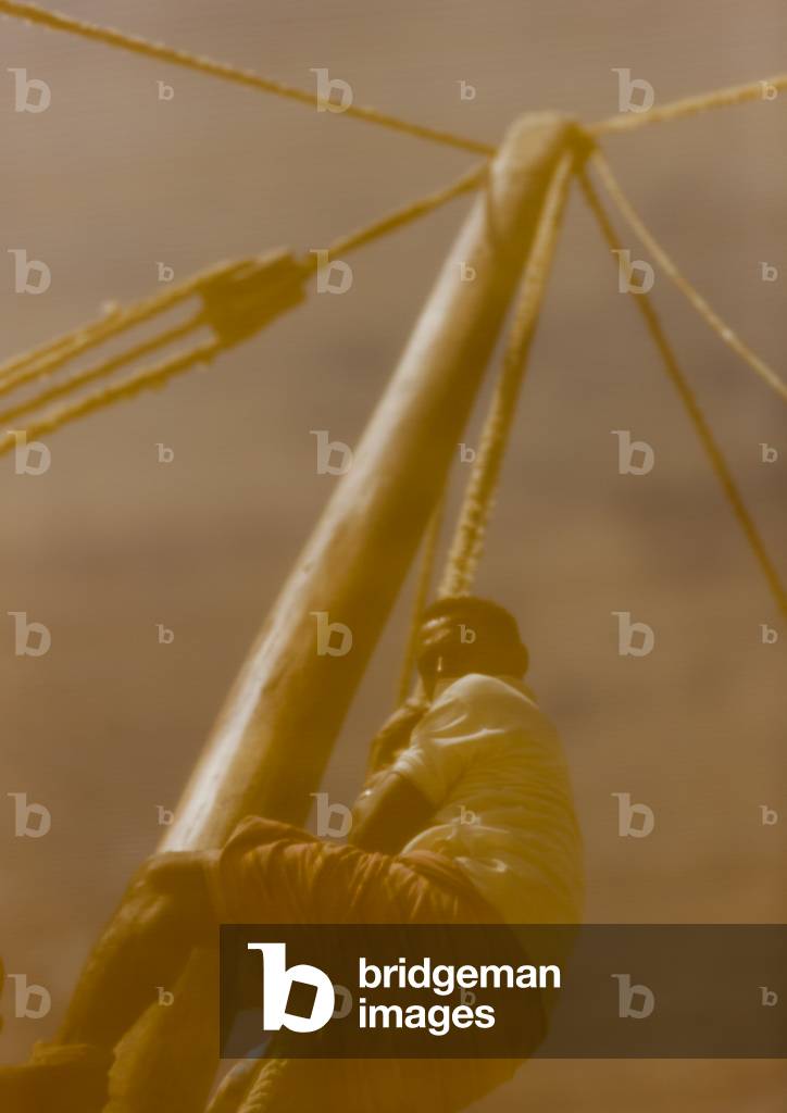 Jeune garçon grimpant sur le mât du dhow swahilina près de lamu, Kenya, Afrique (photo)
