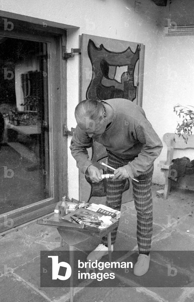 Curd Juergens pittura una porta di legno, 1959 (foto b/n)
