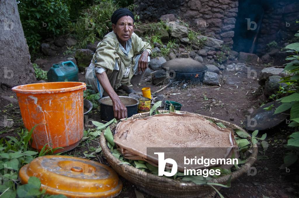 Image Of Woman Cooking Injera Pancake Like Bread On A Mogogo Over By image-of-woman-cooking-injera-pancake-like-bread-on-a-mogogo-over-by