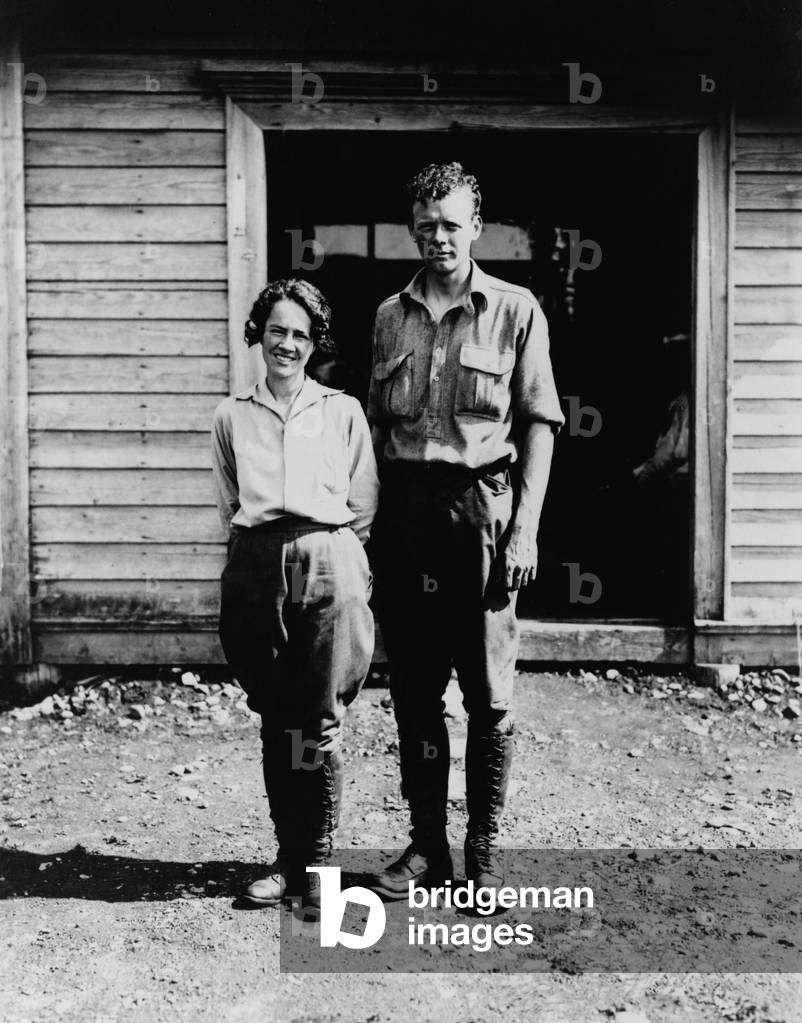 Charles and Anne Morrow Lindbergh, standing in front of cabin on
