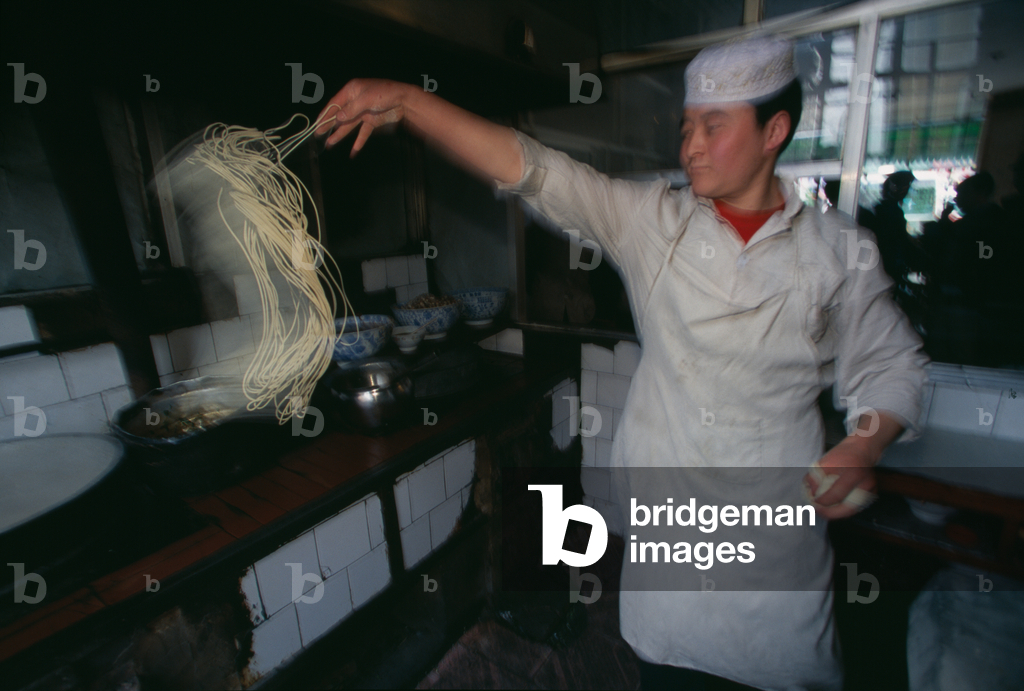 Image of A chef makes Tiao zi, literally 'pulled strings,' that are by ...