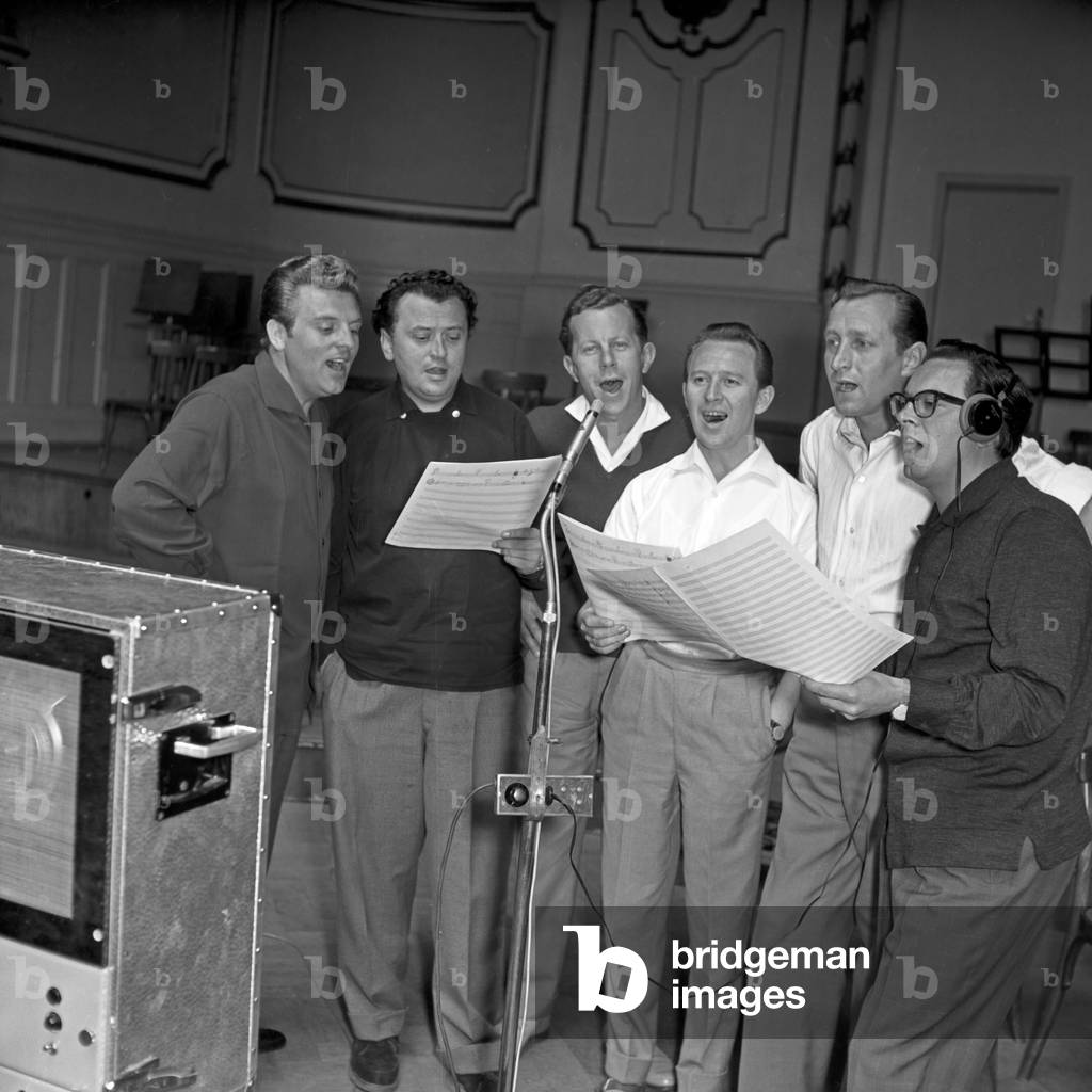 "Il cantante Franco Duval (3° da sinistra) che fa le prove nella sua camera d'albergo a Berlino", b/w