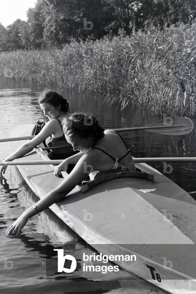 Bild von Fotografie "Zwei junge Frauen in Badeanzügen paddeln in einem Boot", b/w