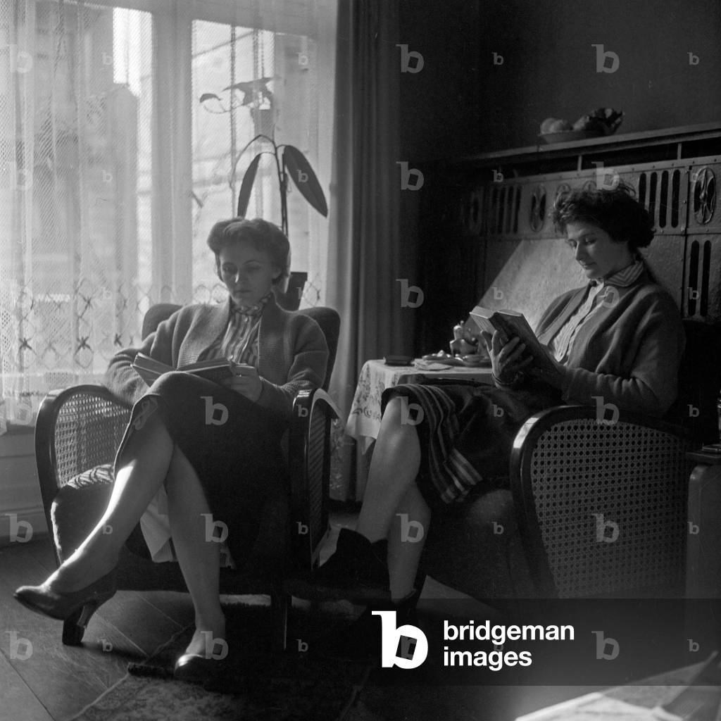 Due donne sedute in salotto e leggere libri, Germania anni '50