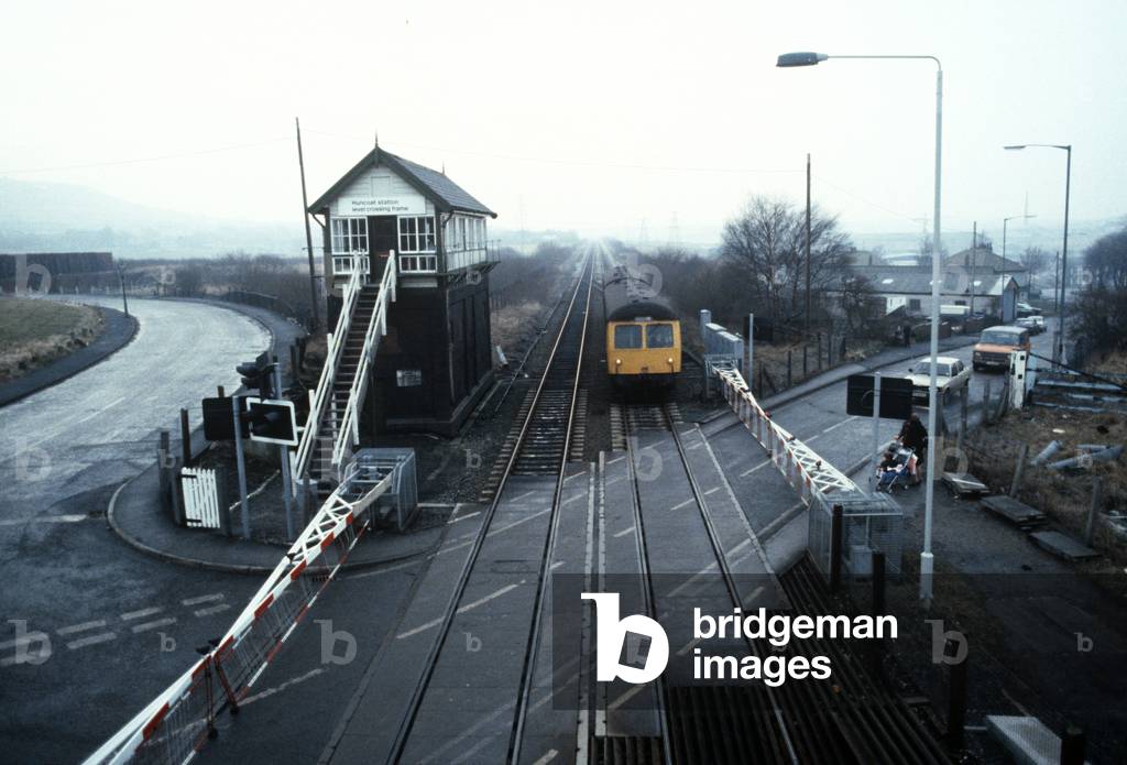 Diesel Multiple Unit on British Rail Preston to Colne railway line at Huncoat level crossing,  Lancashire, Gre