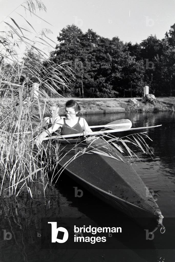 Bild von Fotografie "Junges Paar paddeln in einem Boot auf einem See nahe dem Fluss", b/w