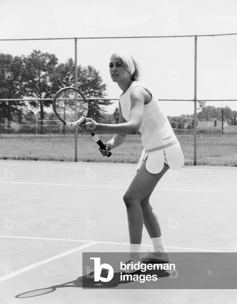 Giovane donna che gioca a tennis su un campo da tennis