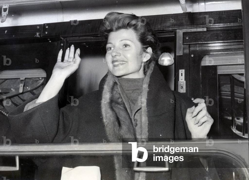 Rita Hayworth saluta i suoi fan da un treno alla Gare Saint Lazare, 3 febbraio 1957 (foto b/n)