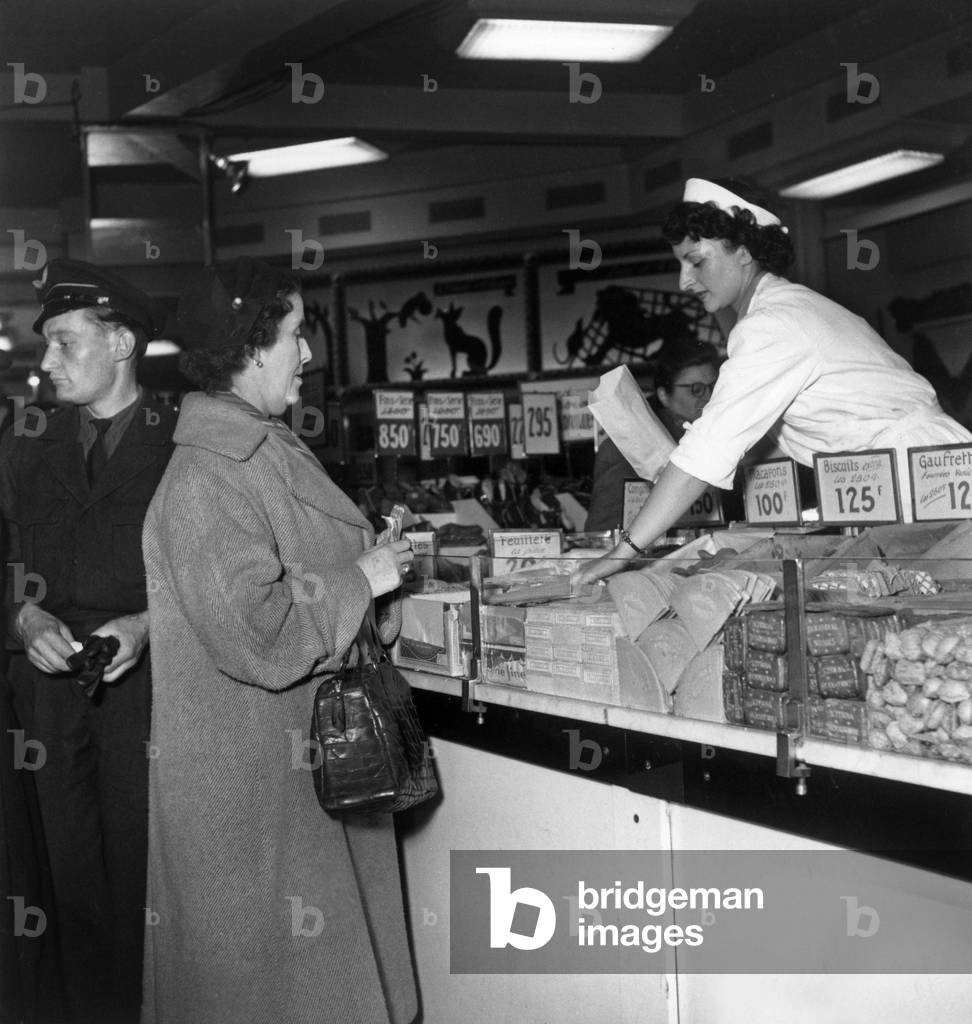 Image of Photography depicting Woman Selling Biscuits in A Store Paris 1951, b/w