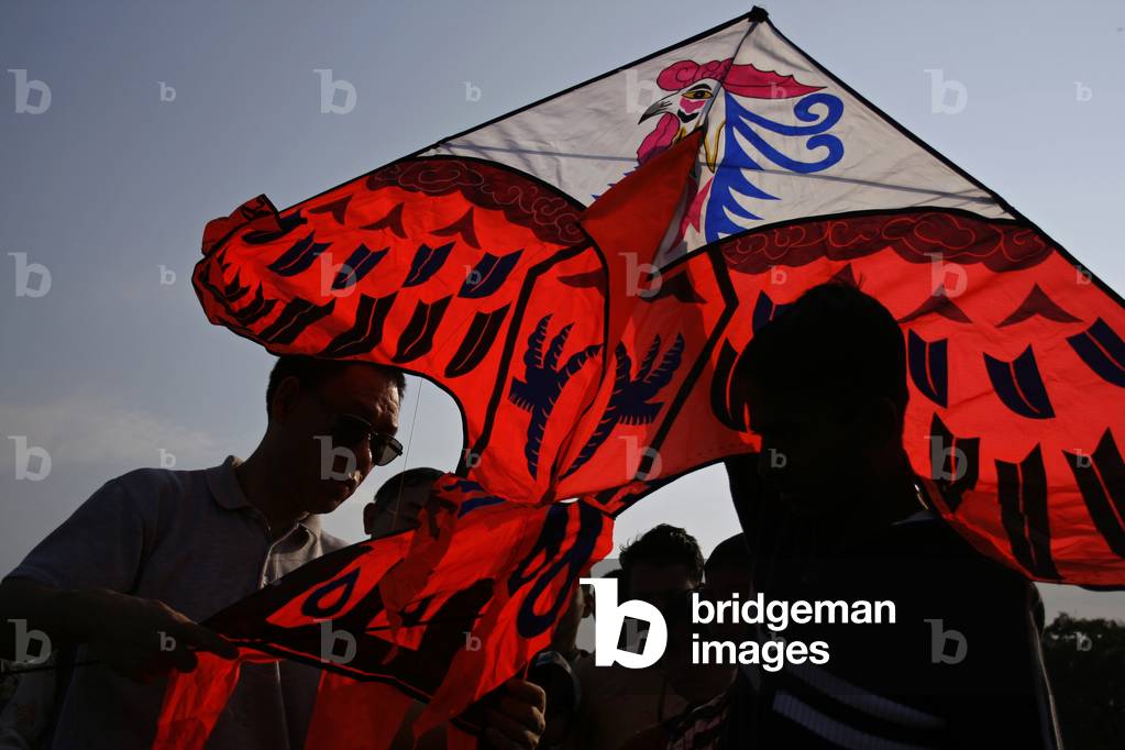 Immagine di Fotografia "Uno straniero prepara il suo aquilone con alcuni ragazzi del Bangladesh durante il fes