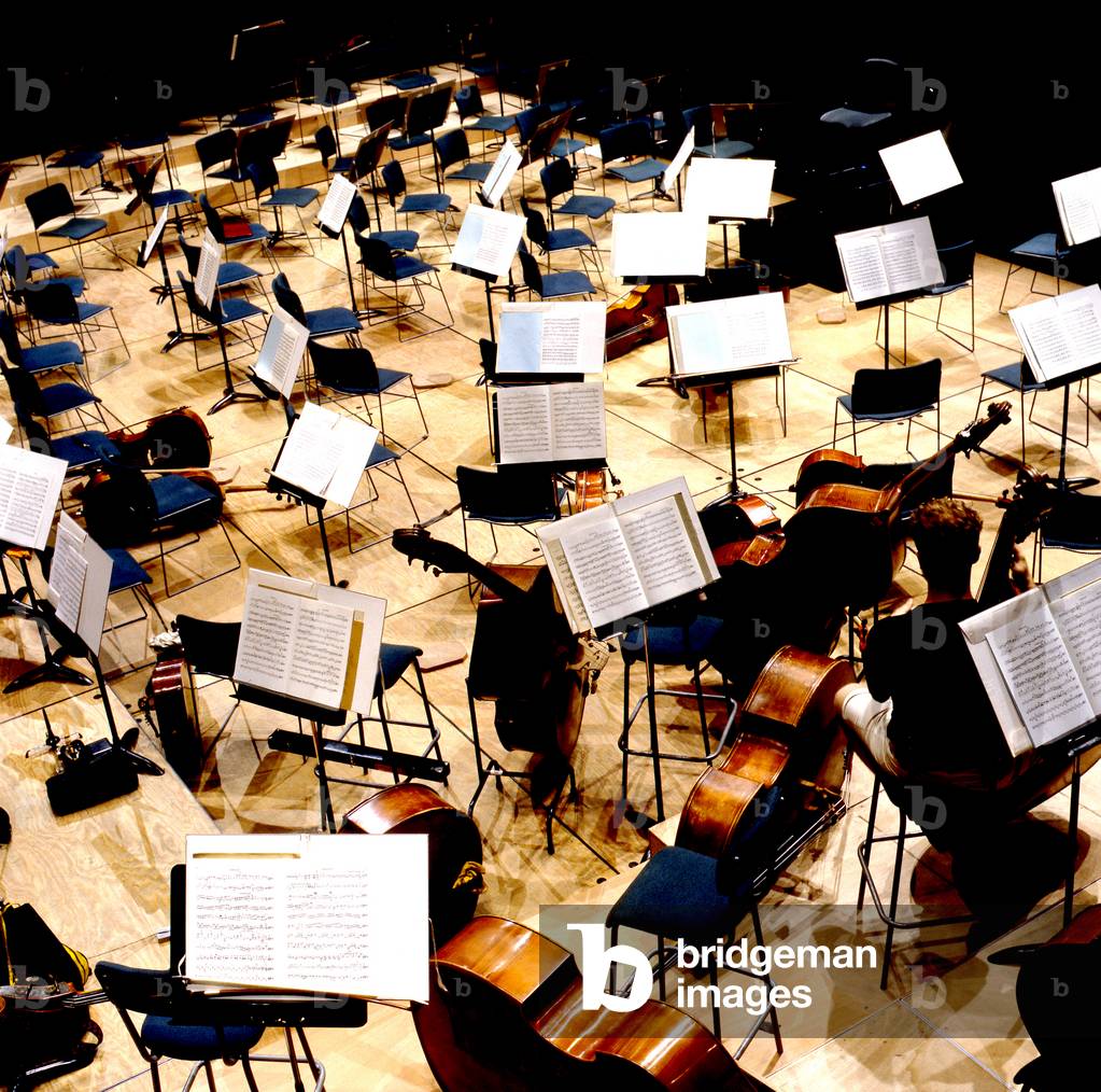 Bild von Fotografie "Bühnenaufstellung für Orchester mit Notenständen und offenen Partiturblättern" von Thierr