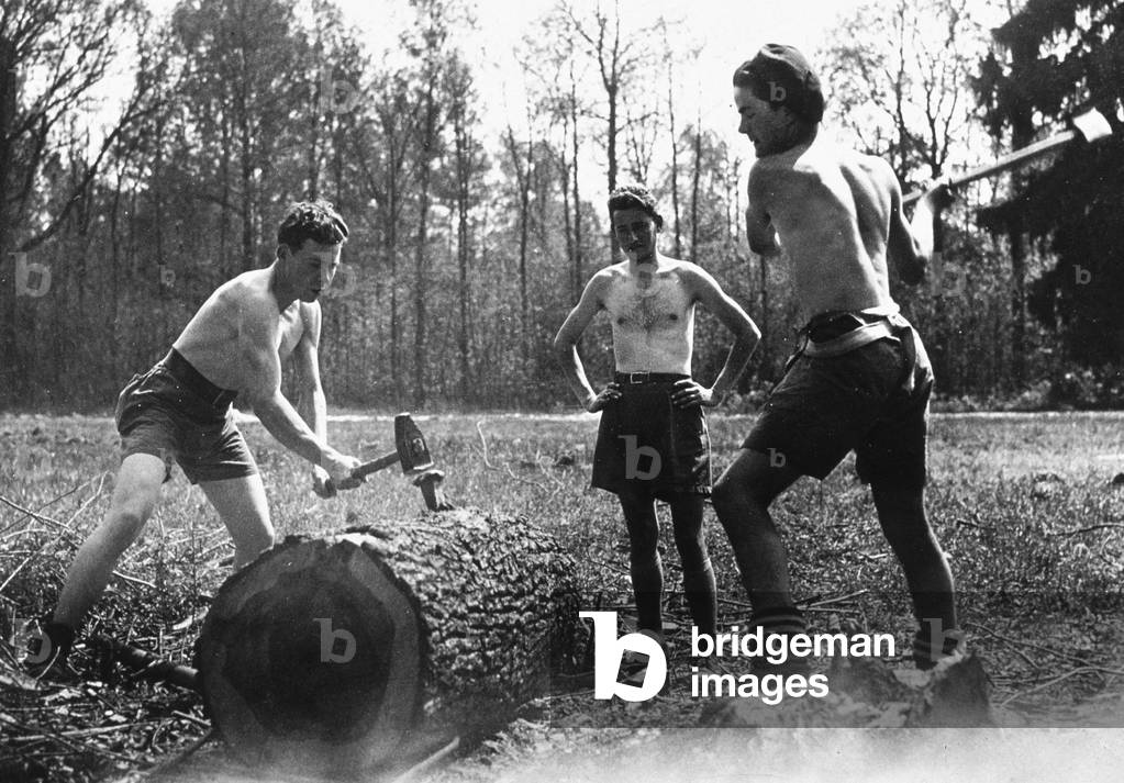 Bild von Fotografie "Jugendlager: junge Holzfällerlehrlinge arbeiten unter den Augen ihres Kapitäns um 1941-19