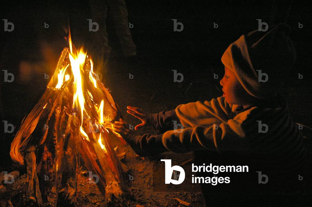Ein Junge wärmt sich am Feuer in einer Winternacht. Durgapur, Netrokona, Bangladesch. 30. Dezember 2005. (Foto