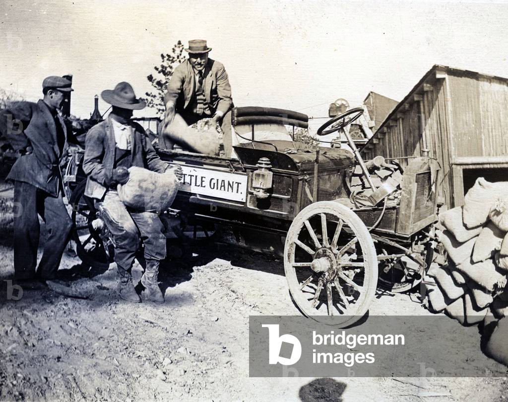 Immagine di Fotografia "Uomini scarico sacchi da un camion", 1910 di American Photographer