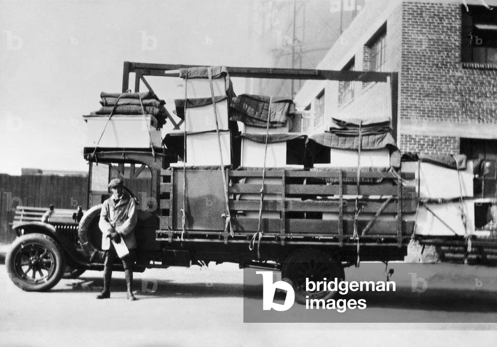 Image of Photography depicting Driver standing in front of a truck by Unknown photographer, b/w